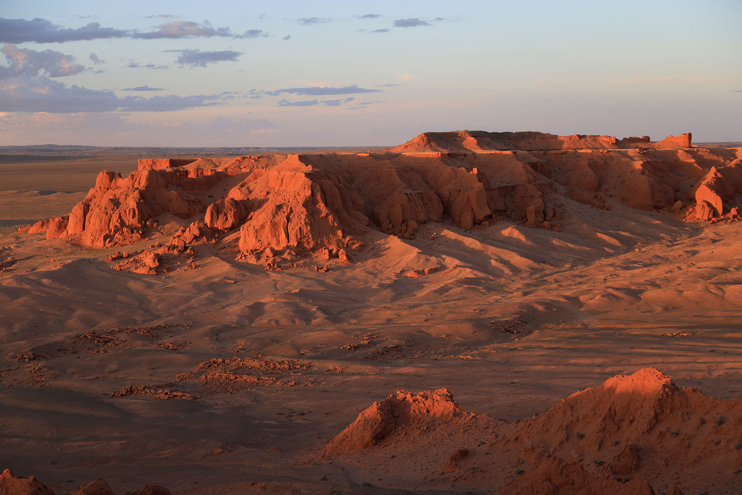 Glowing red-orange Flaming Cliffs of Bayanzag at sunset
